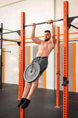 Strong man doing weighted muscle up calisthenics exercise