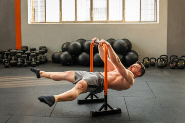 Muscular man performing straddle front lever calisthenics exercise