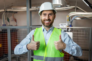 Young caucasian man wearing contractor uniform and safety helmet happy with big smile doing ok sign, thumb up with fingers, excellent sign