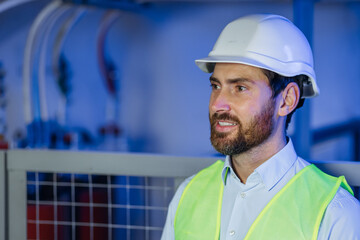 Profile portrait of a serious civil engineer or factory worker wearing a safety helmet and looking aside