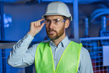 Portrait of Smiling Professional Industry Engineer / Worker Wearing Safety Uniform, Goggles and Hard Hat.