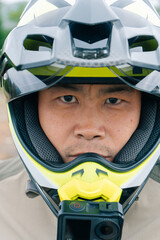 Portrait of a motorcyclist wearing a helmet, serious face, Asian nationality
