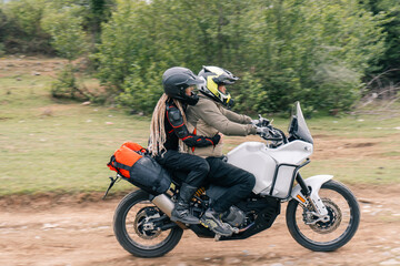 couple of bikers on one motorcycle on off-road moto trip riding adventure motorcycle