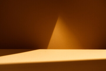 Triangle shadow on brown wall and table. Background with natural shadow for branding products,...