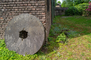 old millstone on a brick wall