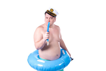 Vacations and holidays. Funny fat man with an inflatable blue circle posing in the studio on a...
