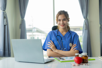 Beautiful young female doctor working with laptop Read electronic medical records Doctors provide...