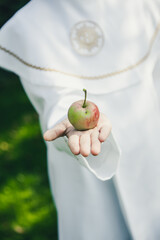 Jabłko w dłoni dziecka idącego do komunii