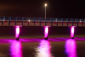 Sea pier adorned multicolored twinkling lights at night symbolizes charm and allure of coastal...