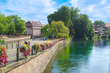 Fototapeta premium city of peace in summer combination of flowers and river, and sidewalk along the river