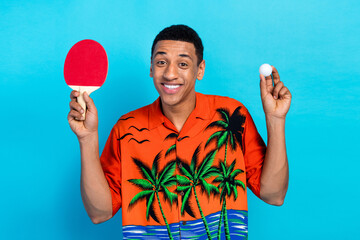 Photo of nice young man hold ping pong racquet ball summer holiday isolated on blue color background