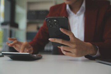 Asian businesswoman in formal suit in office happy and cheerful during using smartphone and working