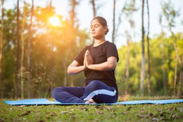 indian women practicing Pranamasana or prayer pose yoga at outdoor morning sunrise