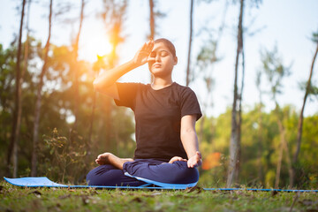 active women practicing pranayama or inhaling breathing exercise at park during sunrise