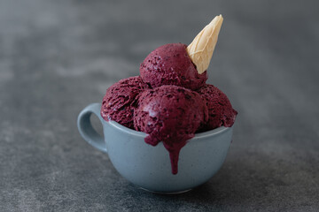 Creamy vegan ice cream from berries or red beets in a mug on a concrete background. Healthy frozen...