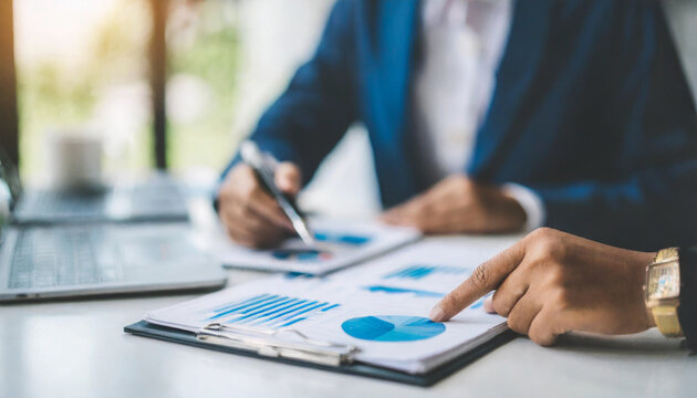 Young business team collaborates on office project, hands focus on report document, symbolizing teamwork and productivity