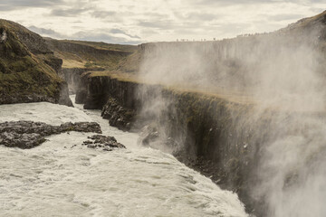 Gullfoss waterfalls in Iceland. Cold fog rises from the river bed. Water falls 32 meters....