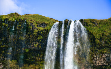Seljalandsfoss waterfall at sunset. Iceland, huge flow of water 60 meters high. Tourism, nature,...