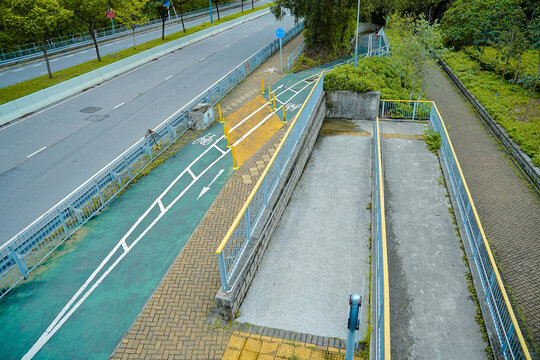 A wide, paved path with a green bike lane and a separate ramp for pedestrians and wheelchairs.