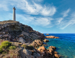 Lighthouse Cabo de Palos on rocky promontory summer view (Cartagena, Murcia, Spain).