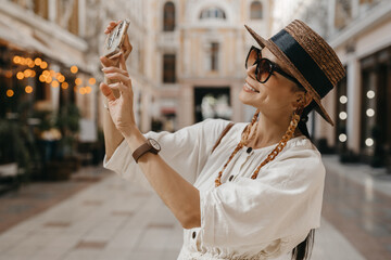 attractive woman walking in shopping street in Italy on vacation dressed in white summer fashion...