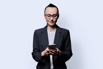 Serious business woman using smartphone on white background