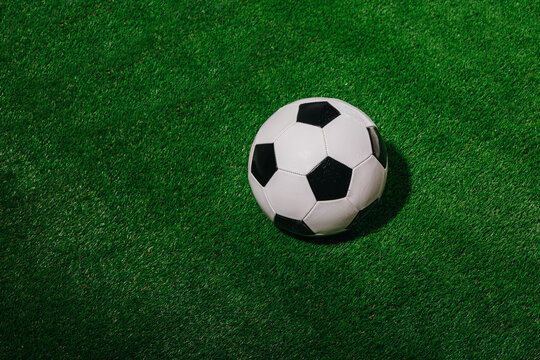 Fototapeta Classic soccer ball on vivid green artificial turf