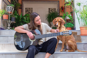 Serenade moment with a guitar and a loving Vizsla mix