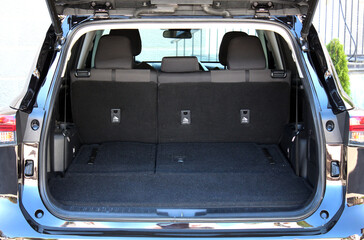 Modern wagon car open trunk. Car boot is open. Clean, open empty trunk in the black car SUV. Front view.