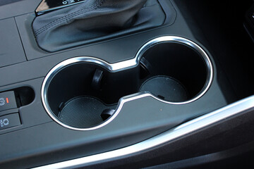 Cup holders in car interior. Closeup car water bottle holder. Car cup holder with heating and...