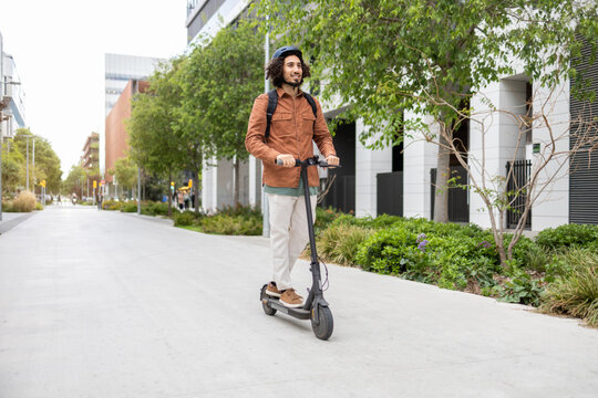 Urban professional riding an electric scooter in modern cityscape