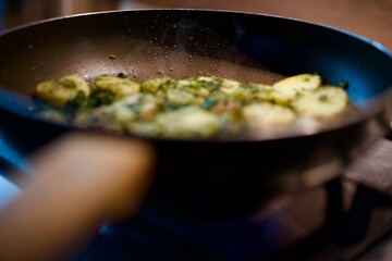 Fried potatoes with herbs in a frying pan