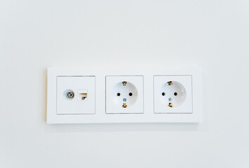 three white electrical outlets on a white wall