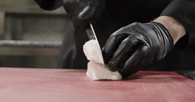 Chef hands chop sheep tail fat on a cutting board. Close-up