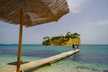 Caméo island panorama from Agios Sostis harbour with a parasol