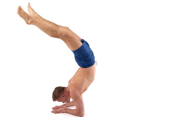 Fitness and meditation. Healthy lifestyle. Young attractive man doing yoga on a white background.