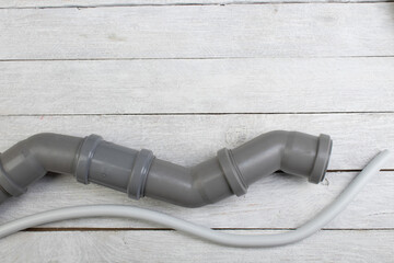 Fittings, pipe, valves, plastic pipe for water, adjustable wrench on the wooden background. Top...