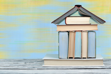 Open book, hardback colorful books on wooden table and blue-yellow background. Back to school. Copy...