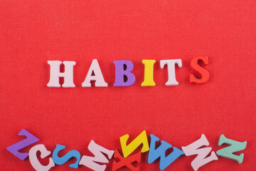 HABITSword on red background composed from colorful abc alphabet block wooden letters, copy space...