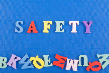 SAFETY word on blue background composed from colorful abc alphabet block wooden letters, copy space...