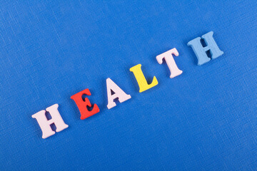 HEALTH word on blue background composed from colorful abc alphabet block wooden letters, copy space...