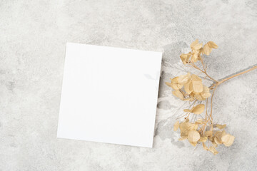 White square paper invitation or flyer card mockup with dry flower decor, copy space for card design
