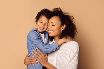 African American woman holding a child in her arms, showcasing maternal care and affection in a heart-warming moment.