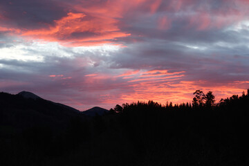 Reddish dawn with the silhouettes of the mountains in the background