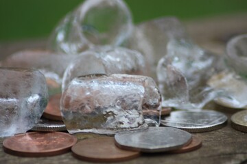 Captivating Still Life Composition Featuring Artfully Arranged Ice Cubes and Coins on a Vintage Wooden Table, Perfect for Retro-Themed Advertising Campaigns and Commercial Projects.