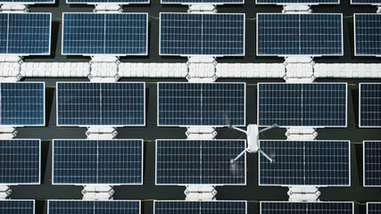 Drone inspects damage on floating solar cells in a river. Renewable energy.