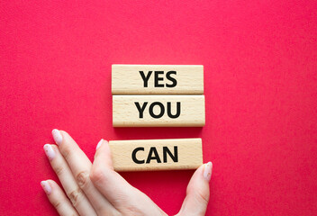 Yes You Can symbol. Concept word Yes You Can on wooden blocks. Beautiful blue background. Businessman hand. Business and Yes You Can concept. Copy space.