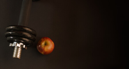 photography of apple and dumbbell on color background, sports background, healthy living, exercise
