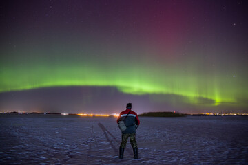 A man admires the polar lights. Night photography.