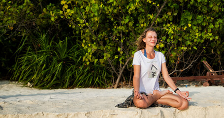 woman doing yoga on tropical beach